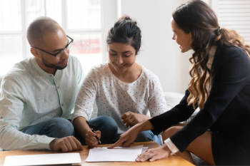 People Looking Over A Mortgage Scenario With Loan Officer