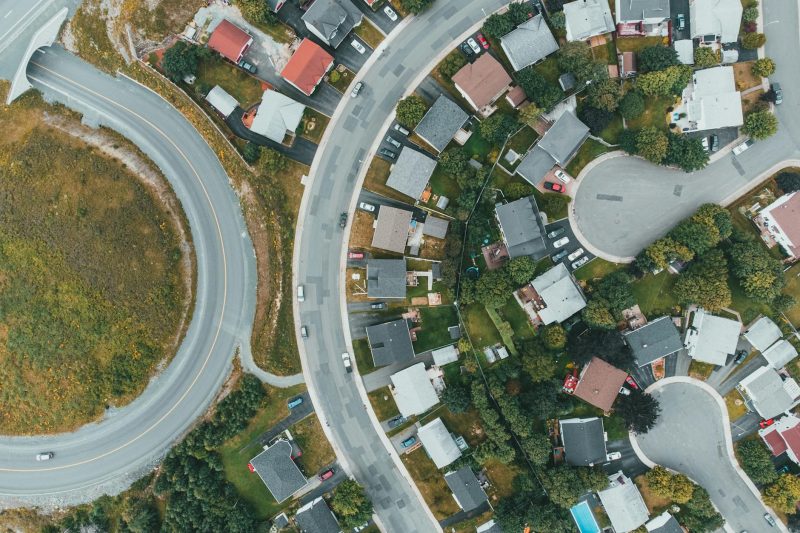 Aerial view of a suburban neighborhood with curved roads and houses, showcasing modern urban planning